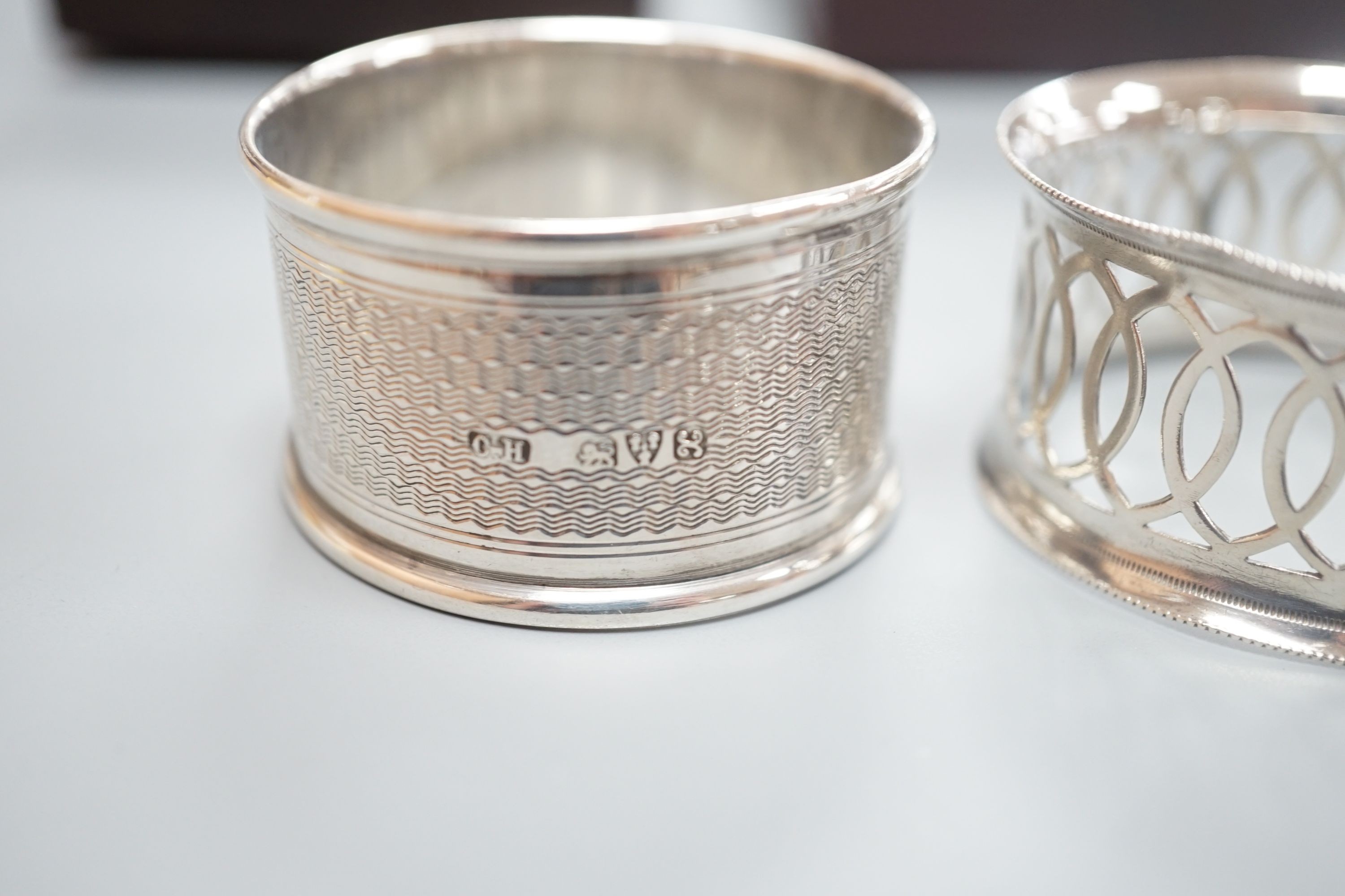 A cased pair of George V engine turned silver napkin rings, by Charles Horner, Chester, 1923 and an Edwardian cased pair of silver napkin rings.